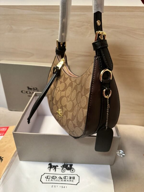 the Coach Kelo Hobo Shoulder Bag, a pinnacle of style and functionality. Crafted with first-quality materials, this bag measures 21 x 18 cm