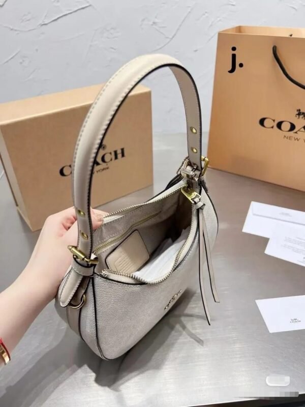the Coach Kelo Hobo Shoulder Bag, a pinnacle of style and functionality. Crafted with first-quality materials, this bag measures 21 x 18 cm